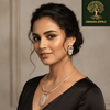 Rose gold necklace set with layered oval geometric pendant and matching earrings, accented with diamond-inspired detailing, displayed on a satin background showcasing modern luxury jewellery design.