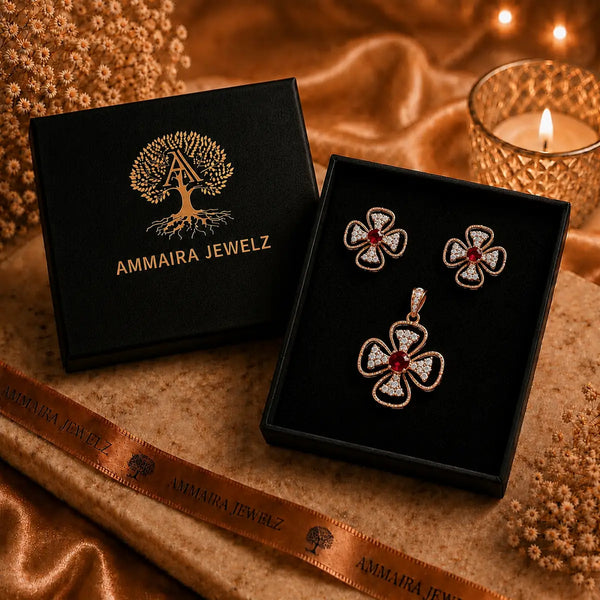 Rose gold Cubic Zirconia pendant set with matching floral-inspired earrings, red centre stones, sparkling clear CZ accents and elegant four-petal design by Ammaira Jewelz.