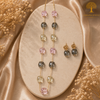 Elegant gold polish mala set with blush pink, smoky grey, and champagne crystal beads paired with matching designer earrings displayed on a model and luxury jewelry stand.
