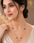 Elegant gold polish mala set with blush pink, smoky grey, and champagne crystal beads paired with matching designer earrings displayed on a model and luxury jewelry stand.