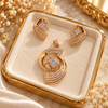 Rose gold American diamond pendant set featuring an open circular design, square clear centre stone, curved sparkling bands and matching statement earrings.