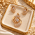 Rose gold American diamond pendant set featuring an open circular design, square clear centre stone, curved sparkling bands and matching statement earrings.