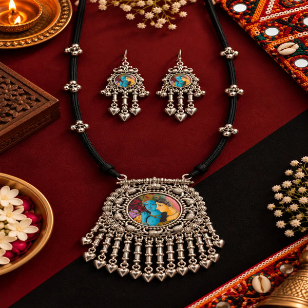 Antique oxidised Radha Krishna necklace set with black thread detailing, statement pendant and matching dangler earrings for women.