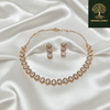 Rose gold necklace set with circular diamond-inspired motifs and matching drop earrings, displayed on a satin fabric background, showcasing elegant and minimal luxury jewellery design.