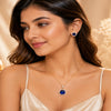 Imperial sapphire blue halo pendant with matching American diamond stud earrings in premium gold-tone finish, pendant set without chain.