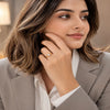 Elegant gold plated solitaire finger ring with a sparkling round crystal displayed in luxury jewelry boxes and worn by a stylish woman.