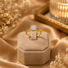 Elegant gold plated solitaire finger ring with a sparkling round crystal displayed in luxury jewelry boxes and worn by a stylish woman.