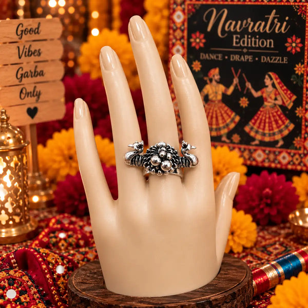 Antique oxidised silver alloy adjustable statement finger ring featuring twin peacock motifs and a beaded floral cluster.