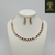 Modern rose gold necklace set with alternating square geometric motifs and matching stud earrings, displayed on a satin background, showcasing minimal luxury jewellery design.