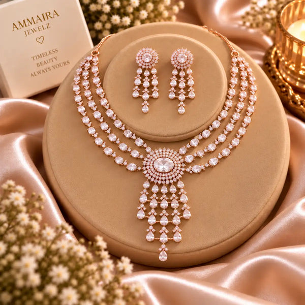 Three-layer Rose Gold Cubic Zirconia necklace set with matching dangling earrings, featuring an oval halo centrepiece and cascading teardrop stone pendant.