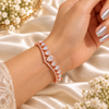 Rose gold premium brass bracelet featuring clear zirconia teardrop stones and delicate sparkling accents with 18K rose gold polish.