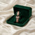 Rose gold bracelet in a green velvet box on a beige fabric background