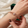 Rose gold bracelet on a wrist with a neutral background