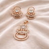 Rose gold jewelry set with earrings and a pendant on a satin surface