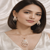 Woman wearing elegant jewelry including earrings and a necklace against a neutral background
