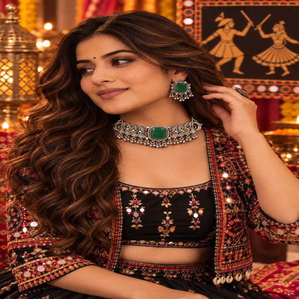 Antique silver-tone oxidized statement choker necklace set for women with green centerpiece, ghungroo drops and matching earrings.