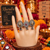 Two-tone fusion oxidised three-finger statement ring featuring peacock and floral motifs with ghungroo accents.