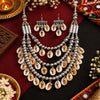 Antique two-tone cowrie shell Navratri necklace set with layered silver-tone beads and matching earrings for women.