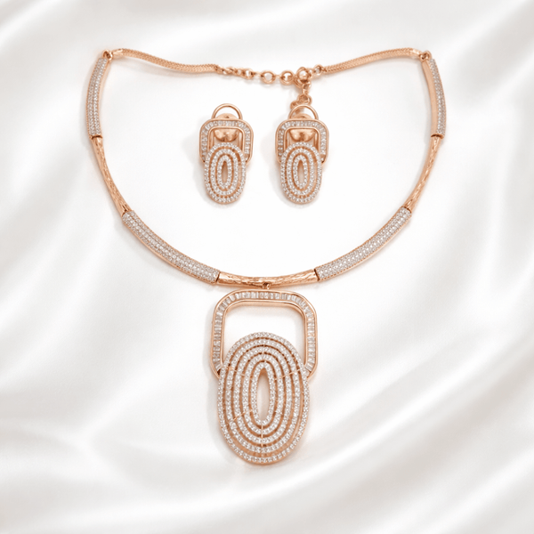 Rose gold necklace set with layered oval geometric pendant and matching earrings, accented with diamond-inspired detailing, displayed on a satin background showcasing modern luxury jewellery design.