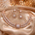 18K rose gold polish American Diamond necklace set with matching drop earrings for women featuring a radiant sunburst design