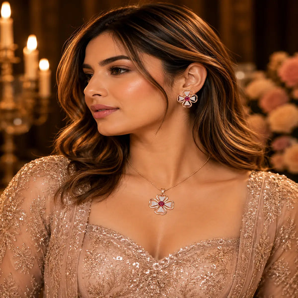 Rose gold Cubic Zirconia pendant set with matching floral-inspired earrings, red centre stones, sparkling clear CZ accents and elegant four-petal design by Ammaira Jewelz.