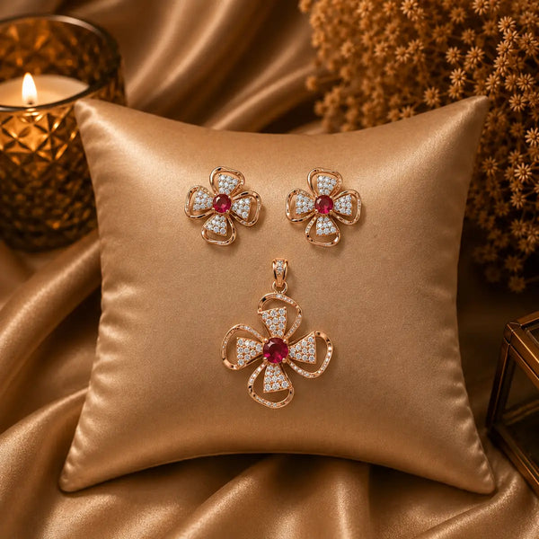 Rose gold Cubic Zirconia pendant set with matching floral-inspired earrings, red centre stones, sparkling clear CZ accents and elegant four-petal design by Ammaira Jewelz.