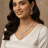 Rose gold necklace set with blush pink oval and rectangular stones, diamond-inspired detailing, and matching drop earrings, displayed on a satin background, showcasing elegant bridal jewellery design.