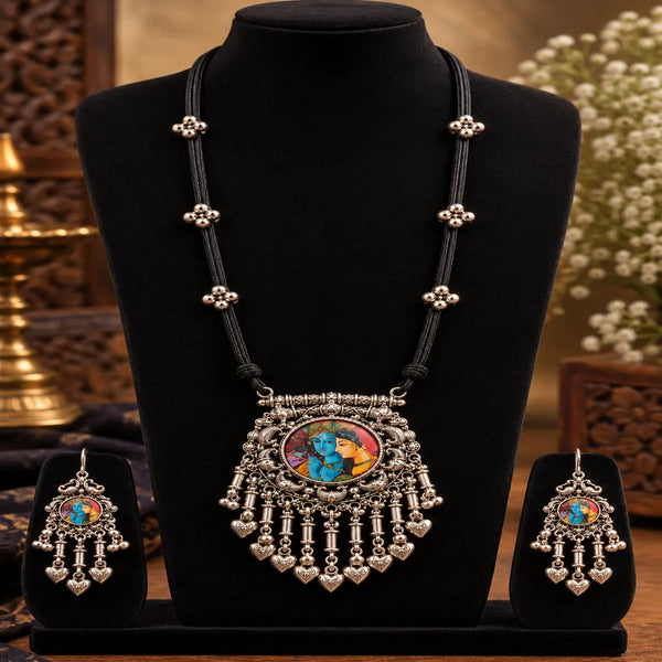 Antique oxidised Radha Krishna necklace set with black thread detailing, statement pendant and matching dangler earrings for women.