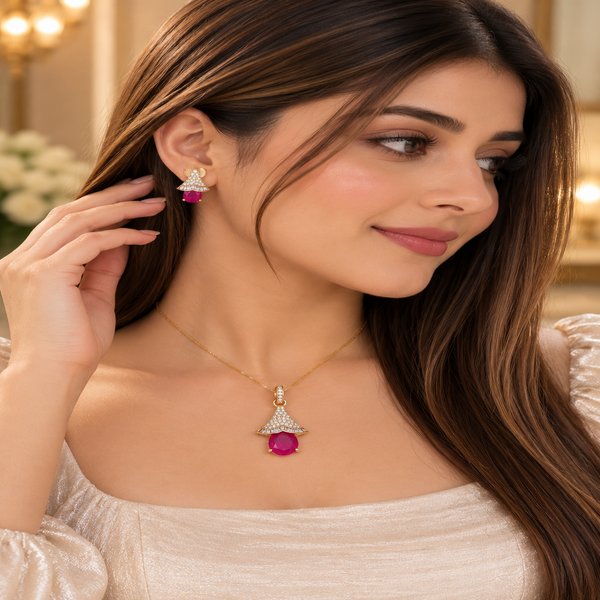 Rose gold American diamond pendant set featuring a ruby-red oval centre stone, sparkling fan-shaped detailing and matching drop earrings.