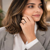 Elegant silver plated solitaire finger ring with a sparkling round crystal displayed in luxury jewelry boxes and worn by a stylish woman.