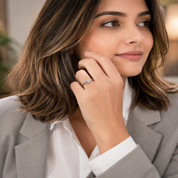 Elegant silver plated solitaire finger ring with a sparkling round crystal displayed in luxury jewelry boxes and worn by a stylish woman.