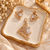 Rose gold American diamond pendant set featuring an angular open lattice design, square clear centre stones and matching geometric earrings.