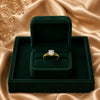 Elegant gold plated solitaire finger ring with a sparkling round crystal displayed in luxury jewelry boxes and worn by a stylish woman.