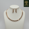 Modern rose gold necklace set with alternating square geometric motifs and matching stud earrings, displayed on a satin background, showcasing minimal luxury jewellery design.