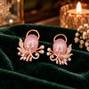 Rose gold floral statement earrings with oval centre stones, leaf motifs and sparkling zirconia detailing, available in ruby red, emerald green, blush pink and deep purple.