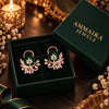 Rose gold floral statement earrings with oval centre stones, leaf motifs and sparkling zirconia detailing, available in ruby red, emerald green, blush pink and deep purple.