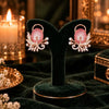 Rose gold floral statement earrings with oval centre stones, leaf motifs and sparkling zirconia detailing, available in ruby red, emerald green, blush pink and deep purple.