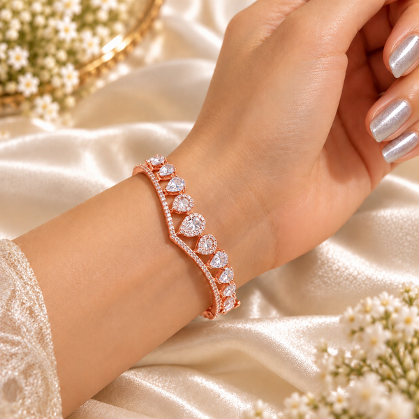 Rose gold premium brass bracelet featuring clear zirconia teardrop stones and delicate sparkling accents with 18K rose gold polish.