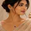 Royal Amethyst Halo American Diamond pendant set with rose gold polish and matching earrings featuring a round purple centre stone.