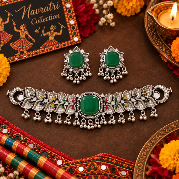 Antique silver-tone oxidized statement choker necklace set for women with green centerpiece, ghungroo drops and matching earrings.