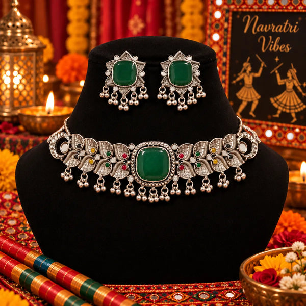 Antique silver-tone oxidized statement choker necklace set for women with green centerpiece, ghungroo drops and matching earrings.