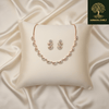 Rose gold scalloped necklace set with diamond-inspired detailing and matching earrings, displayed on a silk cushion against a satin background, showcasing elegant bridal jewellery design.