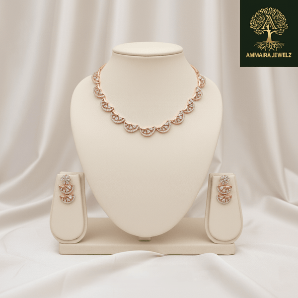 Rose gold scalloped necklace set with diamond-inspired detailing and matching earrings, displayed on a silk cushion against a satin background, showcasing elegant bridal jewellery design.