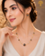 Elegant gold polish mala set with smoky grey and iridescent crystal beads paired with matching crystal earrings displayed on a model and luxury jewelry stand.