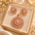 Rose gold American diamond pendant set featuring a circular halo pendant with a central clear stone, marquise-shaped accents and matching sunburst earrings.
